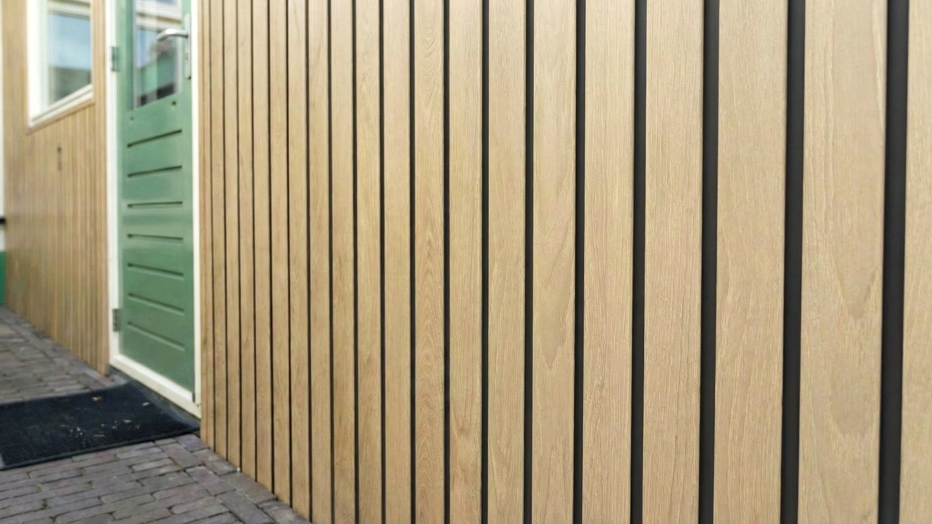 Fronto Oak V-Black gevelbekleding met groene deur en zwarte naden in detail