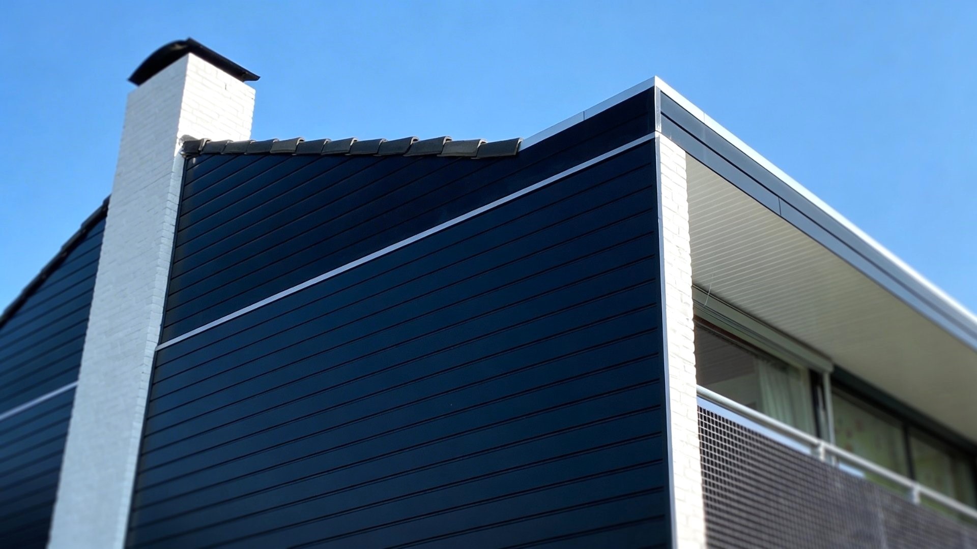 Keralit sponningdeel 143 zwart op gevel met balkon en schoorsteen