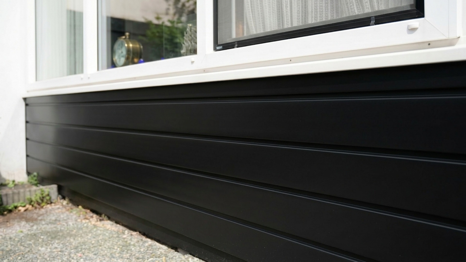 Detail van Keralit sponningdeel 143 zwart gemonteerd als strakke kunststof gevelbekleding