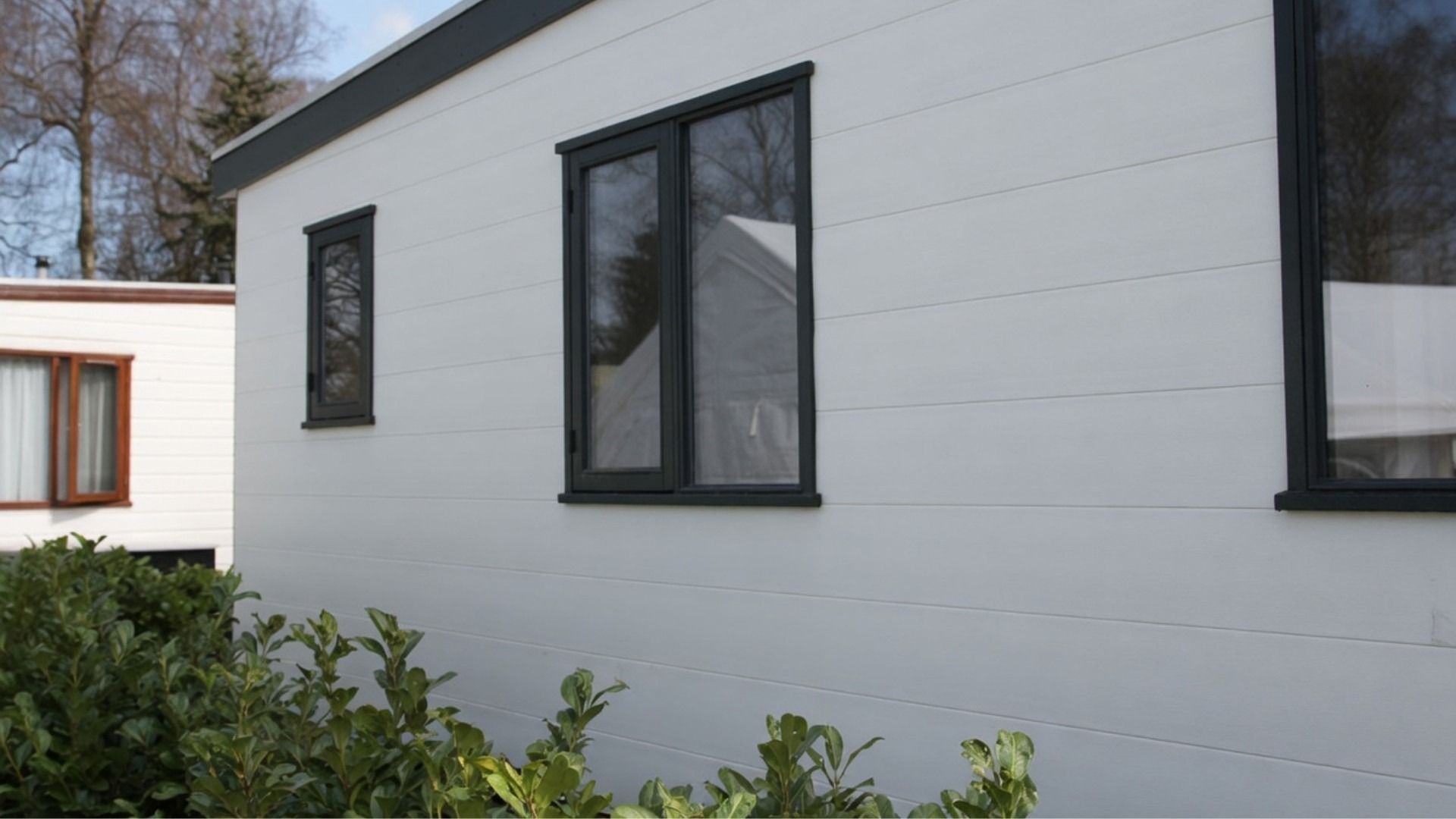 Multitexx V-groef sponningdeel in wit toegepast als kunststof gevelbekleding op een chalet