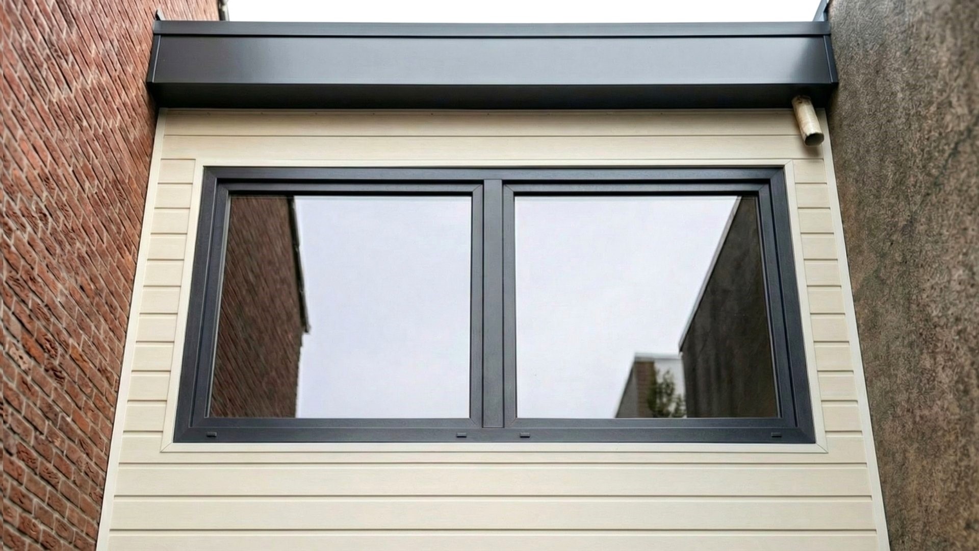Profex velling crème gevelbekleding rondom raam en dakrand Profex velling crème gevelbekleding bij raam met zwarte dakrand